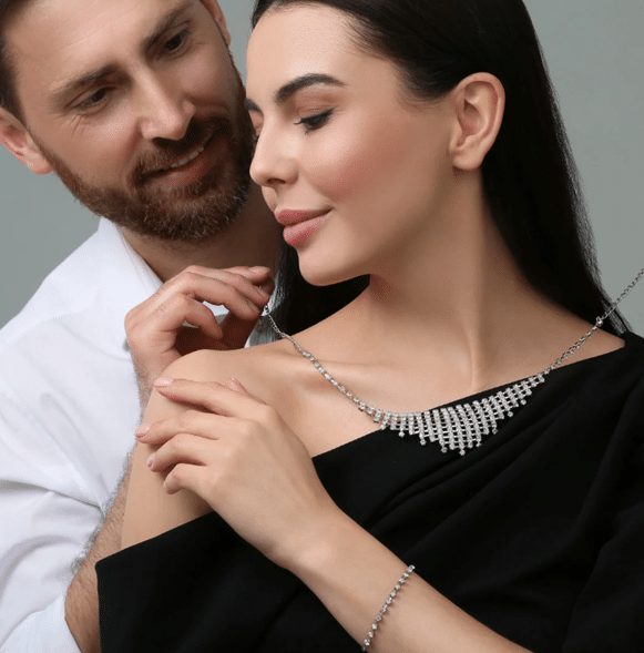 a man putting jewellery around a loved-ones neck.